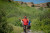 a guide at ht head smashed in buffalo jump is scene pointing out something to his left while leading two people through the outdoor trail of the site.