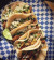 tacos from tacos made in Mexico are sitting a piece of blue and white checkered tacos. the tacos are topped with onion and cilantro.
